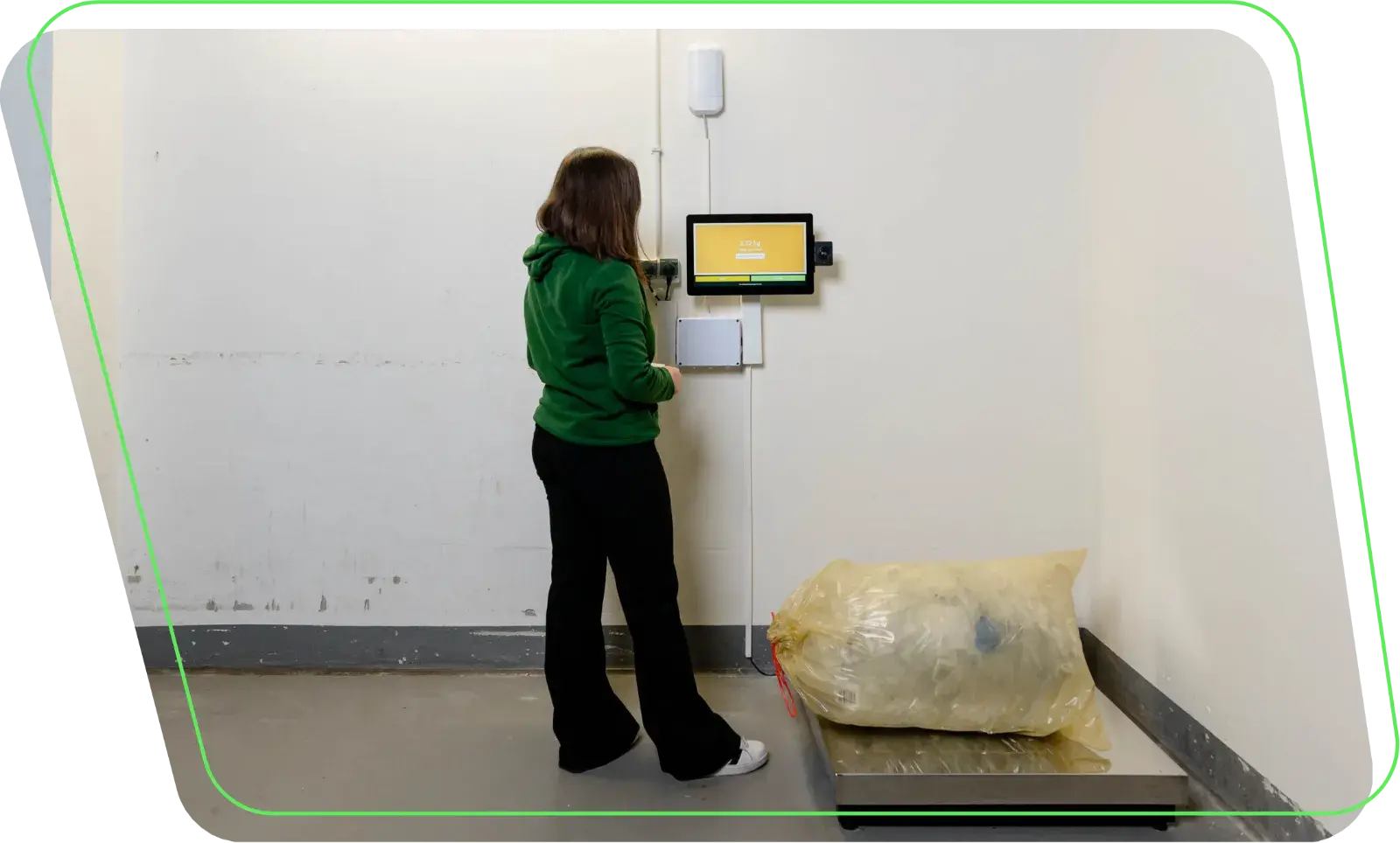 Frau wiegt Plastikabfall am WasteTracker Terminal